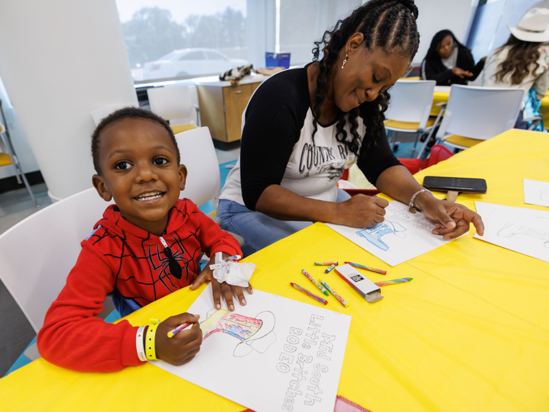 Children's of Mississippi patient Simon Johnson of Petal smiles while coloring with his mom Jo Ann McNair.